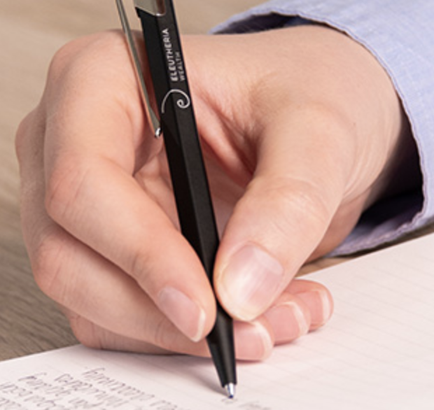 The pen resting in the hand, the pointing finger along the top of the pen